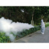 Operator in protective gear fogging street park at a distance.